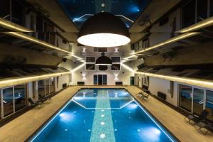 an empty pool in a building with a light fixture at Paradiso Park in Pobierowo