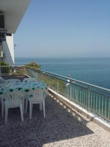 a table and chairs on a balcony overlooking the ocean at To Pithari in Skala Marion