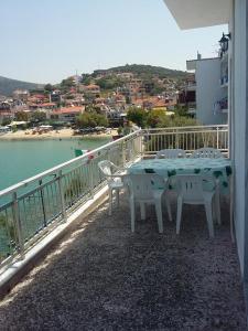 a table and chairs on a balcony overlooking the water at To Pithari in Skala Marion