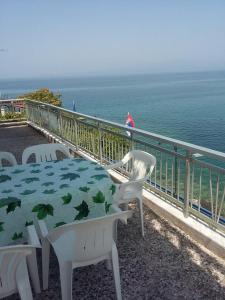 un tavolo e sedie su un balcone con vista sull'oceano di To Pithari a Skala Marion