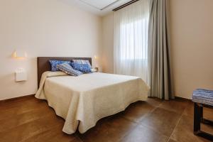 a bedroom with a bed with blue pillows on it at Santa Maria Vecchia Relais in Vico Equense