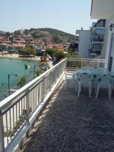 a table and chairs on a balcony overlooking a beach at To Pithari in Skala Marion