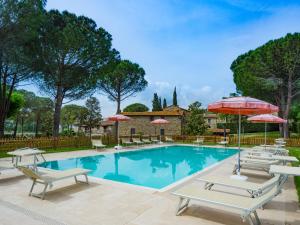 a swimming pool with lounge chairs and umbrellas at La Casa Colonica in Tuoro sul Trasimeno
