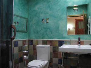 uma casa de banho com um WC, um lavatório e um espelho. em Casa Rural Ulibarri em Allo