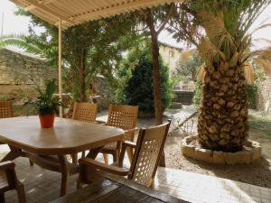 un patio con una mesa, sillas y una palmera en Casa Rural Ulibarri, en Allo