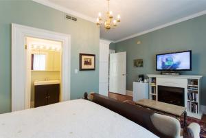 a bedroom with a bed and a tv and a fireplace at Historic Lyons House in Niagara on the Lake
