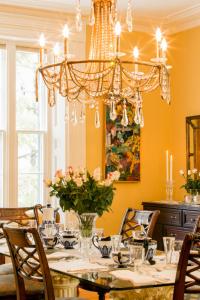 Un comedor con una mesa y una lámpara de araña. en Historic Lyons House, en Niagara on the Lake