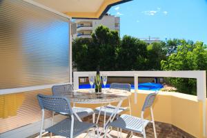 patio con mesa y sillas en el balcón en UHC Alborán Apartments, en Salou