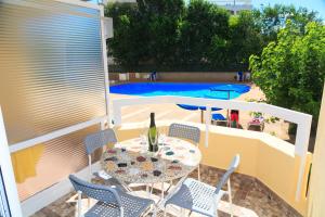 un patio con mesa y sillas y una piscina en UHC Alborán Apartments, en Salou