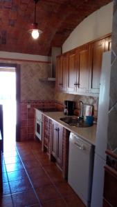 a kitchen with wooden cabinets and a counter top at Apartamentos Rurales Casas de los Maestros in Talarrubias