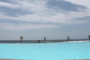une grande piscine d'eau bleue à côté de la plage dans l'établissement Iquique Playa Brava 1670, à Iquique