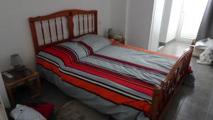 een houten bed in een kamer met een raam bij Appart T4 Luchon plein centre in Luchon