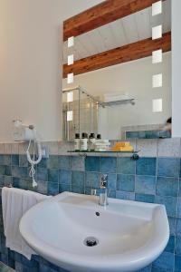 a bathroom with a white sink and a mirror at Agriturismo Casale Degli Ulivi Alghero in Santa Maria la Palma