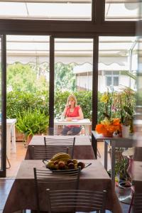 a woman sitting at a table on a patio at Hotel Giulietta e Romeo in Casal Palocco