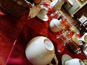 a table with a red table cloth with a tea set at Agriturismo Tenuta San Giuseppe in Cossano Belbo