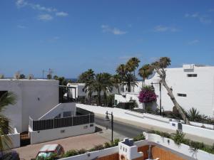 - une vue sur une rue bordée de palmiers et de bâtiments dans l'établissement Apartamentos Colombia Ap 5, à Puerto del Carmen