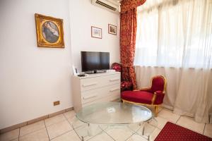 a living room with a glass table and a tv at Hotel Giulietta e Romeo in Casal Palocco