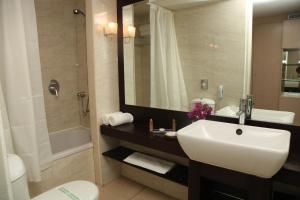 a bathroom with a sink and a toilet and a shower at Sitia Beach City Resort & Spa in Sitia