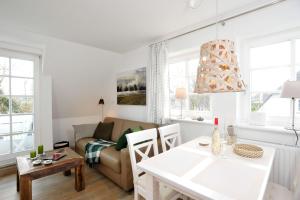 ein Wohnzimmer mit einem Sofa und einem Tisch in der Unterkunft App. Buhne in Westerland