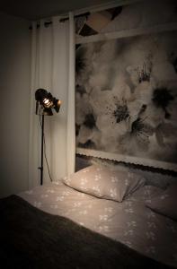 ラハティにあるLahti Alex Houseのベッドルーム1室(ランプと絵画付)