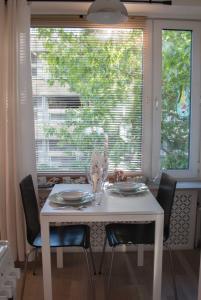 - une table et des chaises blanches dans une chambre avec fenêtre dans l'établissement Lahti Alex House, à Lahti