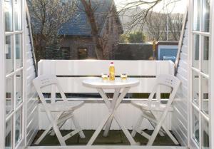 einen weißen Tisch und zwei Stühle auf dem Balkon in der Unterkunft App. Buhne in Westerland