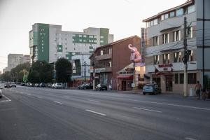 una calle de la ciudad con edificios y una carretera con en Hotel Ioana, en Constanţa