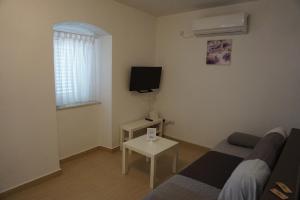 una sala de estar con un sofá y una mesa en Rosa Apartments, en Ist