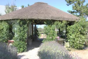 a gazebo with a thatch roof in a garden at Casa Suaya in José Ignacio