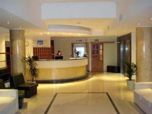 een lobby met een vrouw aan een balie in een gebouw bij Hotel Cuatro Plazas in Casilda