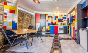 kuchnia z kolorowymi ścianami oraz stołem i krzesłami w obiekcie House Mondrian w mieście Vodnjan