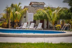 a group of chairs and a pool in front of a house at La Choza Bungalows in Tambo Grande