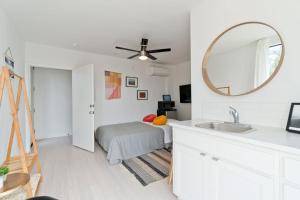 a bedroom with a bed and a mirror and a sink at Steps to the Beach, Rooftop Deck in San Diego