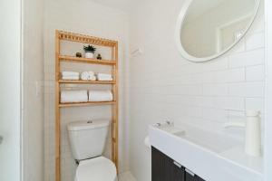 a bathroom with a toilet and a sink and a mirror at Steps to the Beach, Rooftop Deck in San Diego +18 photos