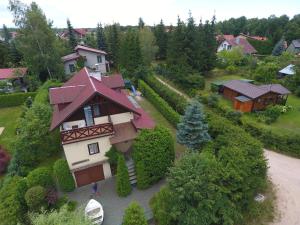 Cudodomek na Mazurach w Woszczelach koło Ełku في إوك: منزل بسقف احمر في ساحة