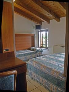 a hotel room with two beds and a window at Alla Basilica in Aquiléia