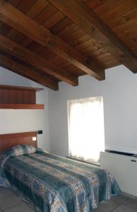 a bedroom with a large bed with a window at Alla Basilica in Aquiléia