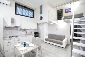eine Küche und ein Wohnzimmer mit einem Tisch und einem Sofa in der Unterkunft Modern Loft Apartment in Rom