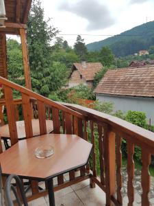 a wooden balcony with a table and a view at Pensiunea Lőrincz *** Panzió in Sovata