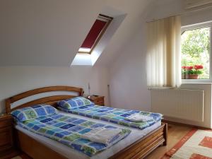 a bedroom with a bed and a window at Pensiunea Lőrincz *** Panzió in Sovata