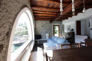 ein Wohnzimmer mit einem Bogenfenster und einem blauen Sofa in der Unterkunft House on the lake shore of Laglio in Laglio