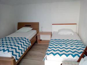 two beds in a small room with a bedskirts at Apartment More Sumartin in Sumartin