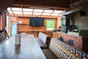 a dining room with a table and chairs and a television at Lodges Zacisze I in Giżycko