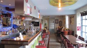 a restaurant with a bar and tables and chairs at Hôtel Au Bord du Monde in Neuvy-sur-Barangeon
