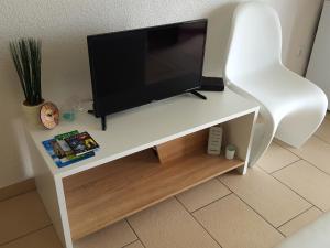 a flat screen tv sitting on top of a white tv stand at Apartments Merion in Starigrad