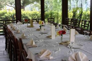 a long table with white table cloths and flowers on it at Locanda del Barone in Caramanico Terme