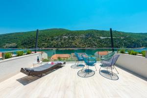 3 sillas y una mesa en un balcón con vistas en Villa Lu sea view-gym-sauna-hot tub,pool, en Mokošica
