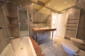 ein Badezimmer mit einer Badewanne, einem WC und einem Waschbecken in der Unterkunft Reet Hausteile Sonnenkliff und Kamp in Gager
