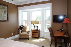 a bedroom with a bed and a desk and a window at Wishmaker House B&b in Bellville