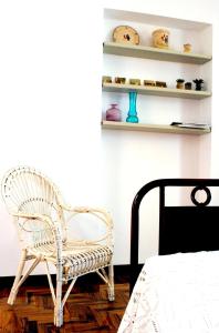 ein Schlafzimmer mit einem weißen Stuhl und einem Regal in der Unterkunft Dimora Romano in Alberobello